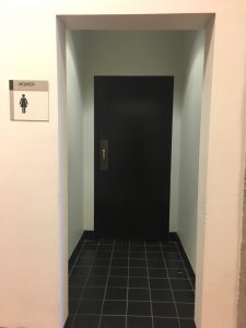 Women's Bathroom in White Hall with small hallway to give more privacy