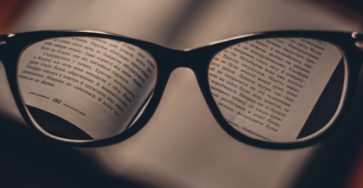 Open book focused through reading glasses