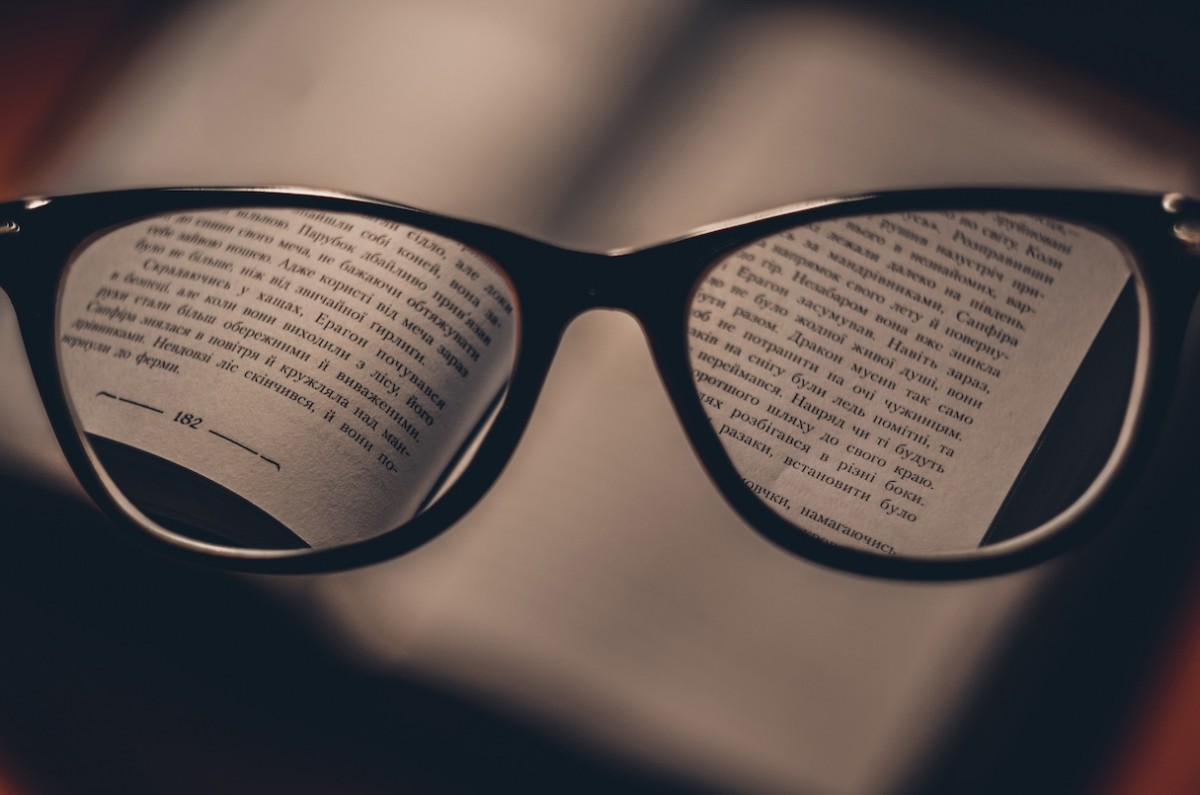 Open book focused through reading glasses