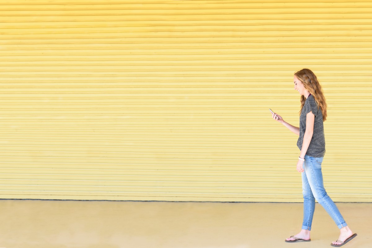 student walking with phone