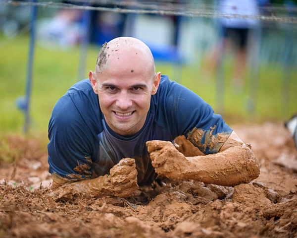 Photo of person doing an obstacle course in the mud