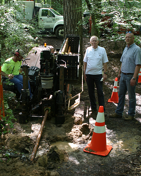 Work crew burying a cable under a creek.