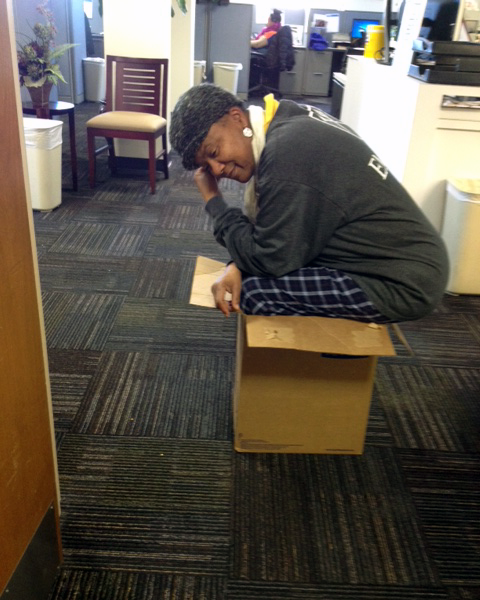 Photo of a woman squating in a box