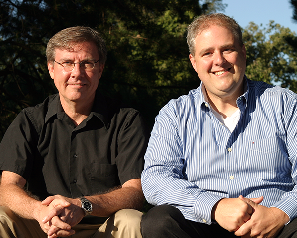 Photo of two employees sitting outside