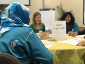 This image shows a refugee woman participating in a community dialogue.