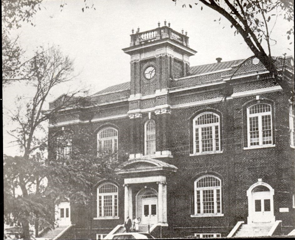 Black and white photo of old brick building on a college campus
