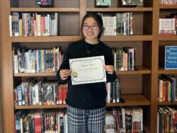 Angela Chan with a certificate that says she is the Student Employee of the Month.