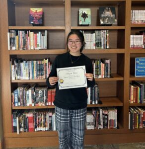  Angela Chan with a certificate that says she is the Student Employee of the Month. 