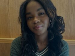 Library leader Faimie smiling in a green sweater