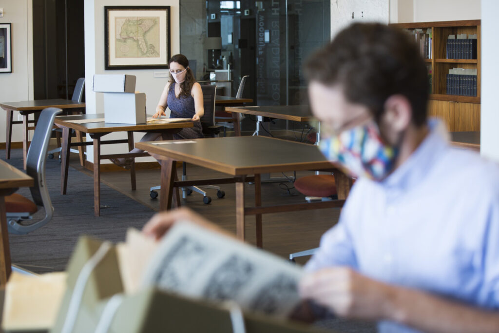 Researchers in the Rose Library wear masks as they peruse archival materials from socially distanced tables.